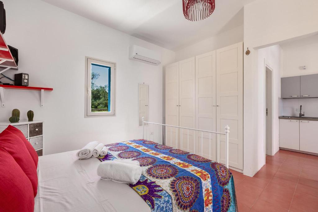Cette chambre blanche dispose d'un lit et d'une cuisine. dans l'établissement Villa Sierri by Perle di Puglia, à Specchiolla