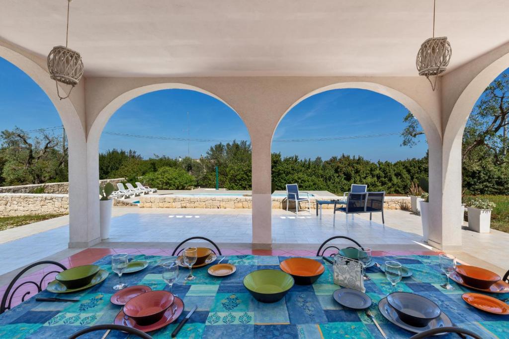 une table avec des bols et des assiettes dessus dans un pavillon dans l'établissement Villa Sierri by Perle di Puglia, à Specchiolla