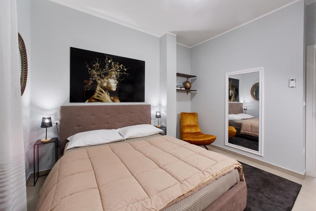 a bedroom with a large bed with a painting on the wall at Showroom Luxury B&B in Reggio Calabria