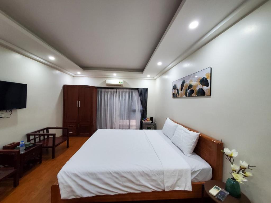 a bedroom with a white bed and a tv at Dodo Home 3 in Hanoi