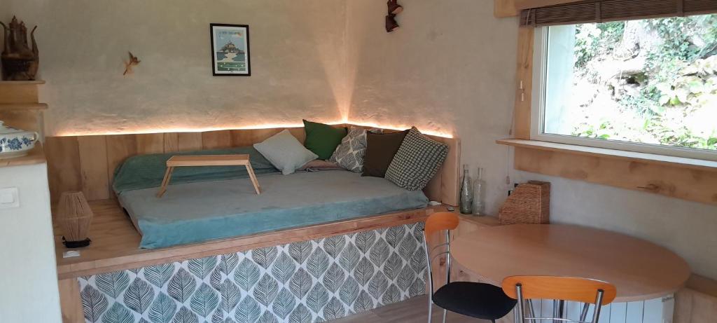 un petit lit dans une petite maison avec une table dans l'établissement La Bergerie, à Saint-Quentin-sur-le-Homme