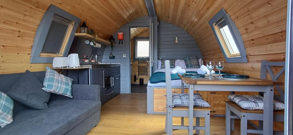 a living room with a couch and a kitchen in a tiny house at Neptune's Rest in Fort William