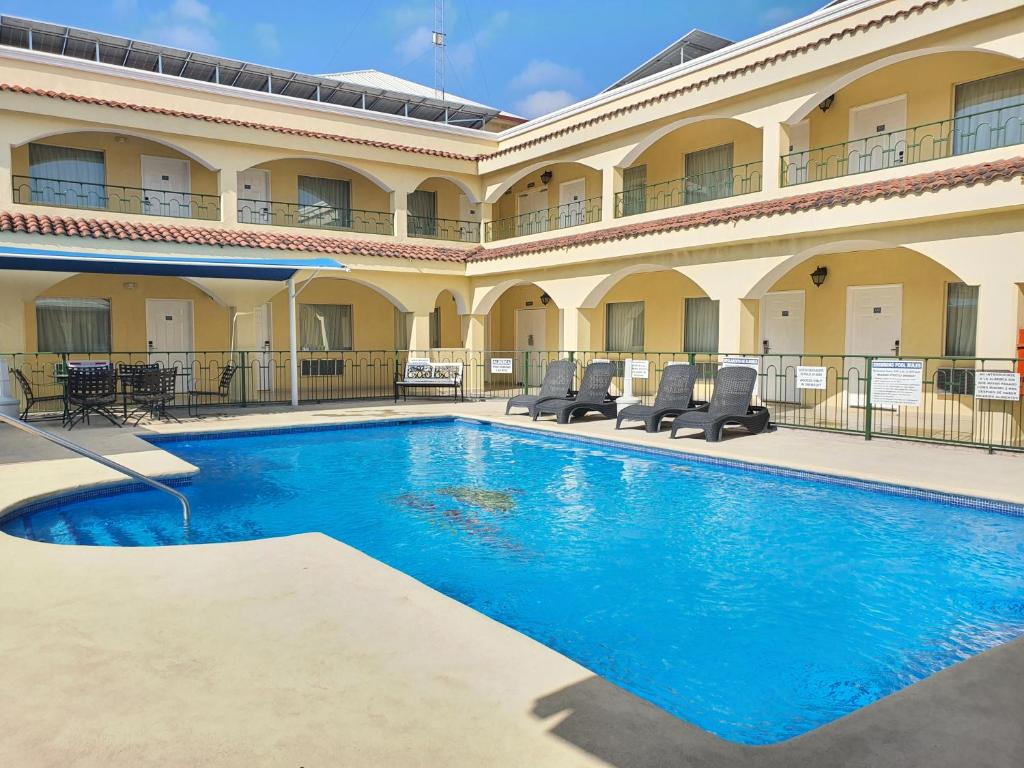 une piscine en face d'un grand bâtiment dans l'établissement Hotel Las Misiones, à Monclova