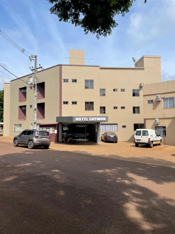 un edificio con auto parcheggiate di fronte di HOTEL SAYMON a Cafelândia