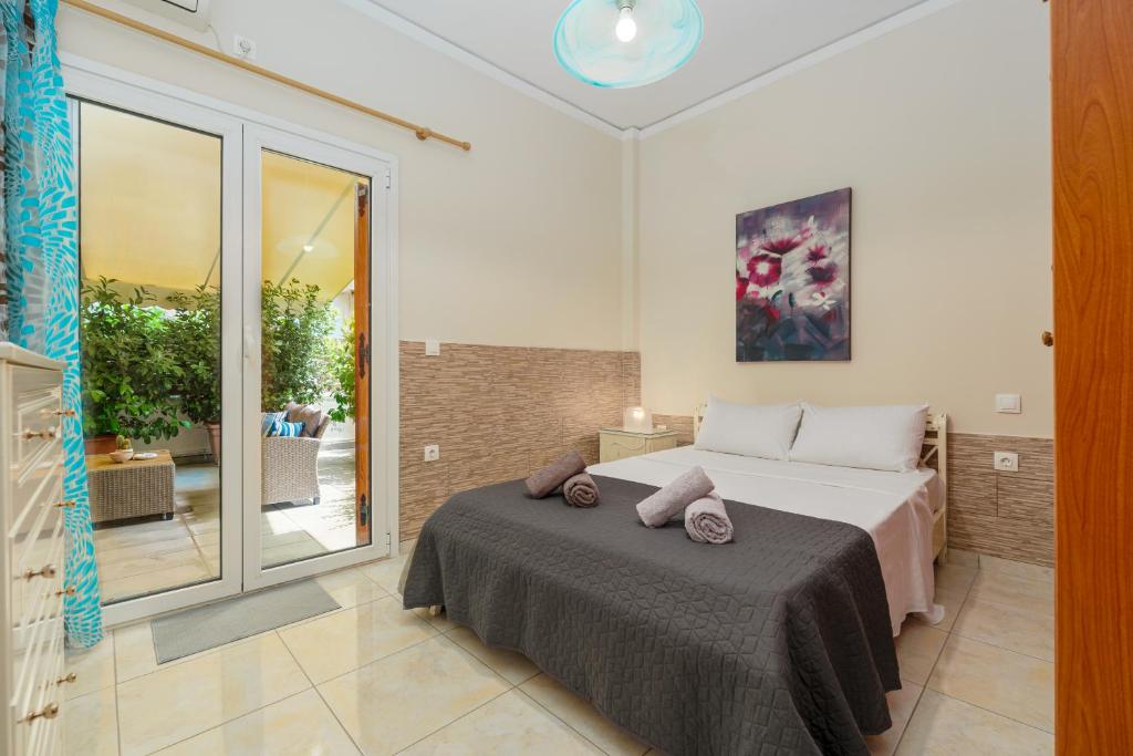 a bedroom with a bed and a large window at Nostos apartment, with a spacious backyard in Artemida