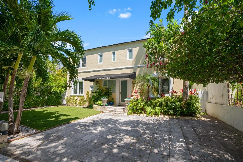 uma casa com palmeiras e uma entrada em villa venezia bb em Miami Beach