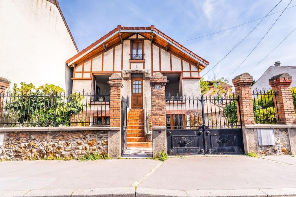 une maison en briques avec un portail en face de celle-ci dans l'établissement maison chalet conviviale, à Aubervilliers