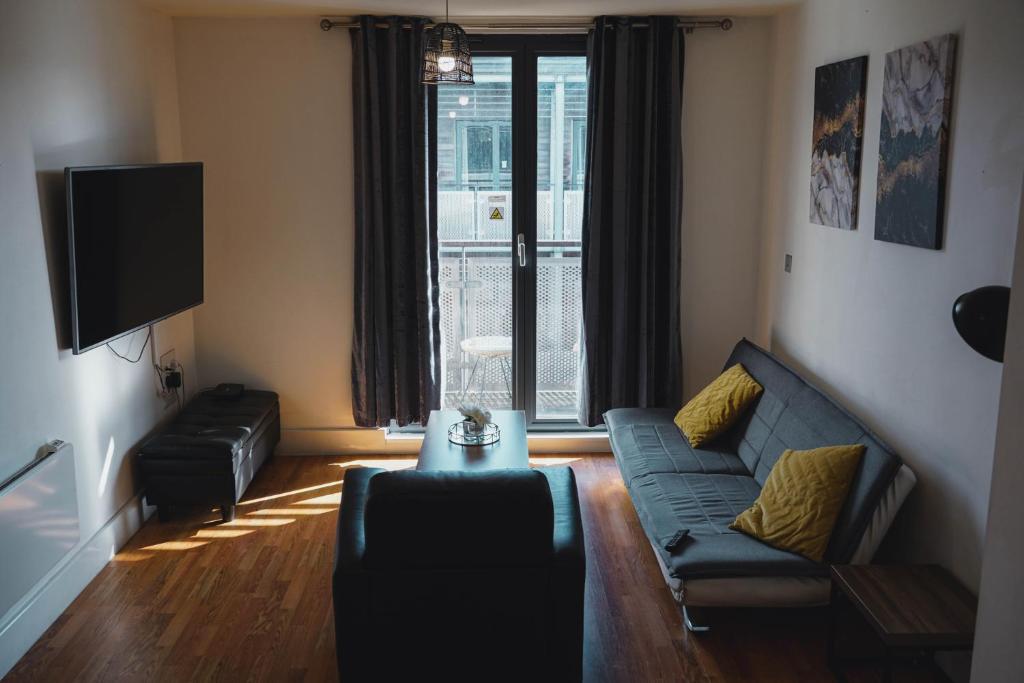 a living room with a couch and a tv at Modern City Nest With Parking in Birmingham