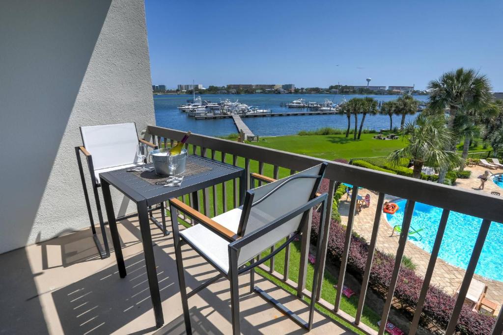 a balcony with a table and chairs and a view of the water at Pirates Bay A308 in Fort Walton Beach