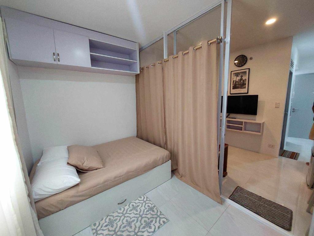 Twin Hearts Residences Unit 215 في مدينة روكساس: غرفة نوم صغيرة مع سرير صغير في غرفة صغيرة