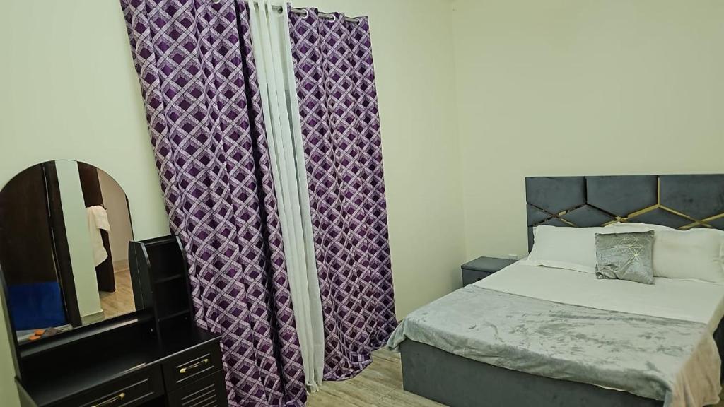 ein kleines Schlafzimmer mit einem Bett und einem Spiegel in der Unterkunft Luxury Rooms in Dubai