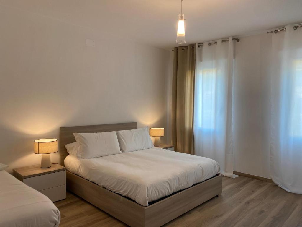 een slaapkamer met een bed met twee lampen erop bij LUME, Family Apartment in Murano