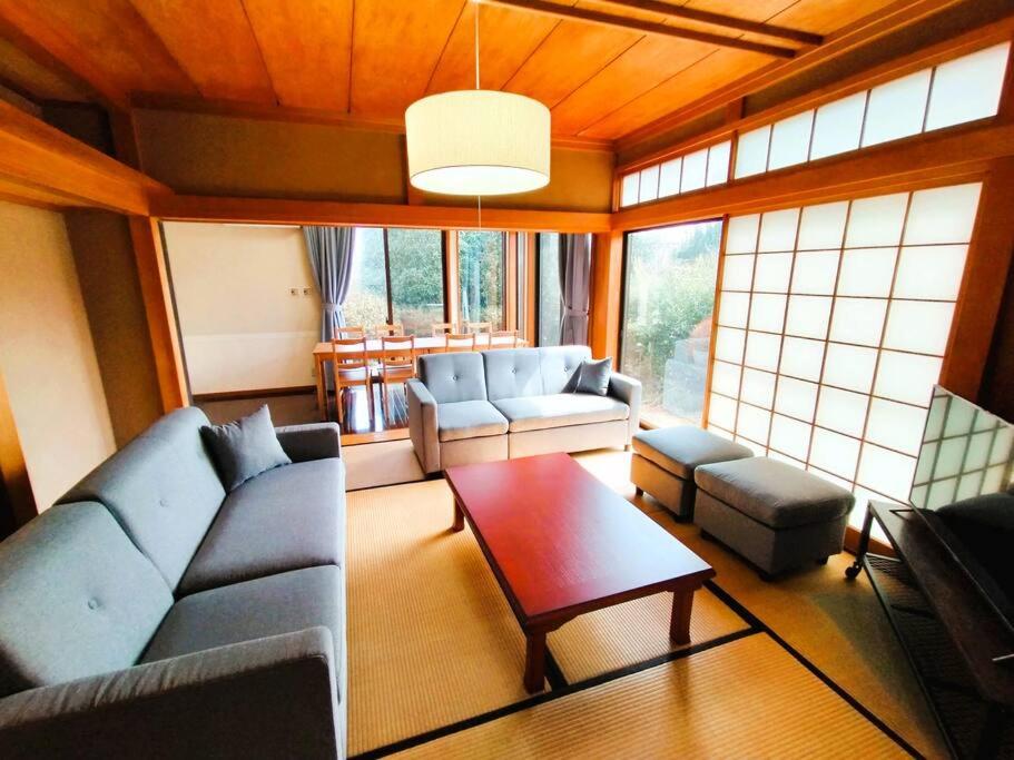 ein Wohnzimmer mit einer Couch und einem Couchtisch in der Unterkunft Nikko Big House - Max 12 Guests Near Station 2 Parking in Nikko