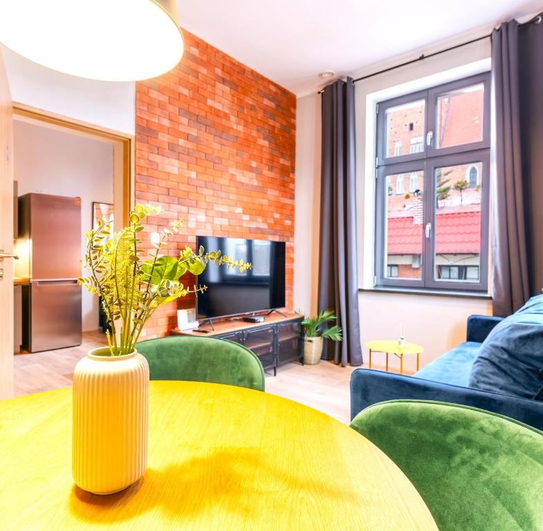 a living room with a table and green chairs at Central LOFT in Nowe Miasto Lubawskie