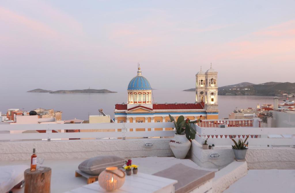 a view of a building with a clock tower on the water at San Nikolas view guest house in Ermoupoli