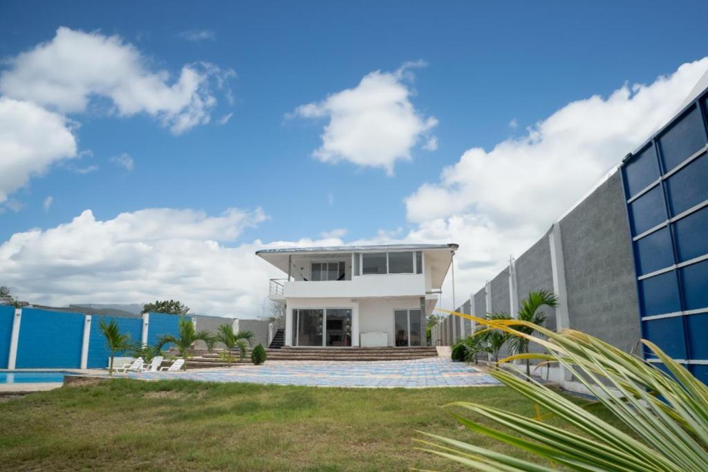 una casa con piscina al lado de un edificio en VILLA VIVA EVENTOS, en Puerto Cayo