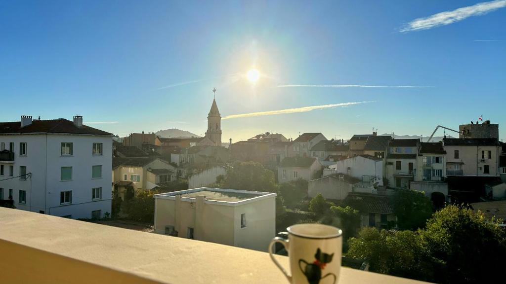 uma chávena de café sentada na borda de uma varanda em Le Schumann em Sanary-sur-Mer