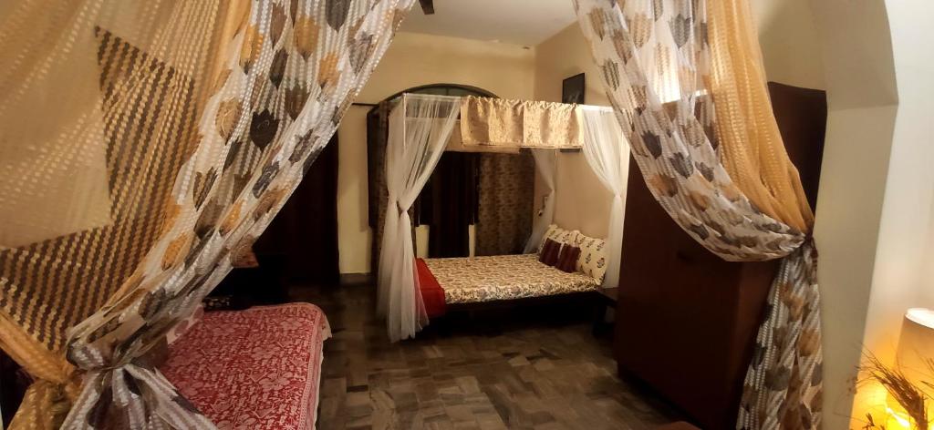 a room with two beds and curtains in it at Home Away From Home in Prayagraj