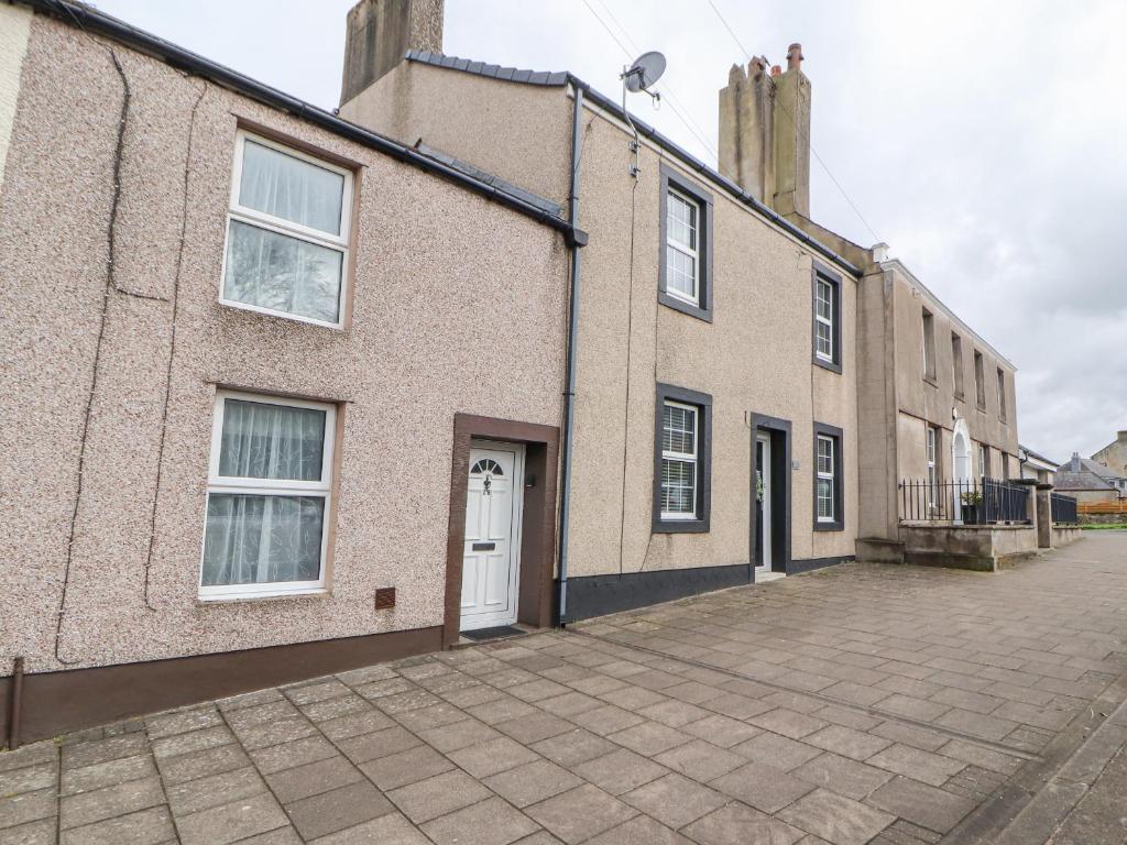 uma rua vazia em frente a um edifício de tijolos em Foxy Lady Cottage em Workington