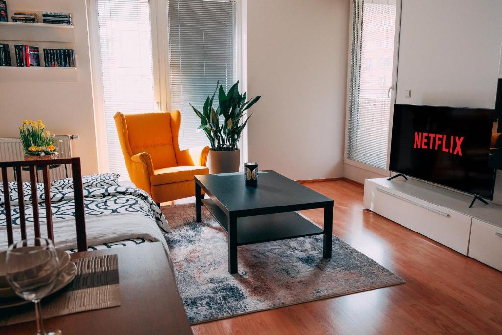 a living room with a tv and a coffee table at Apartmán u METRA, 4 hosté, parking free, blízko O2 arena in Prague