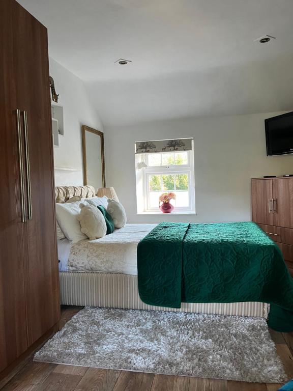 um quarto com uma cama com um cobertor verde em Old Mill House em Larne