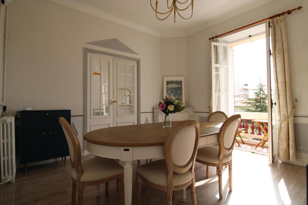 a dining room with a table and chairs at Appartement 1er étage Cottage Reine in Cannes