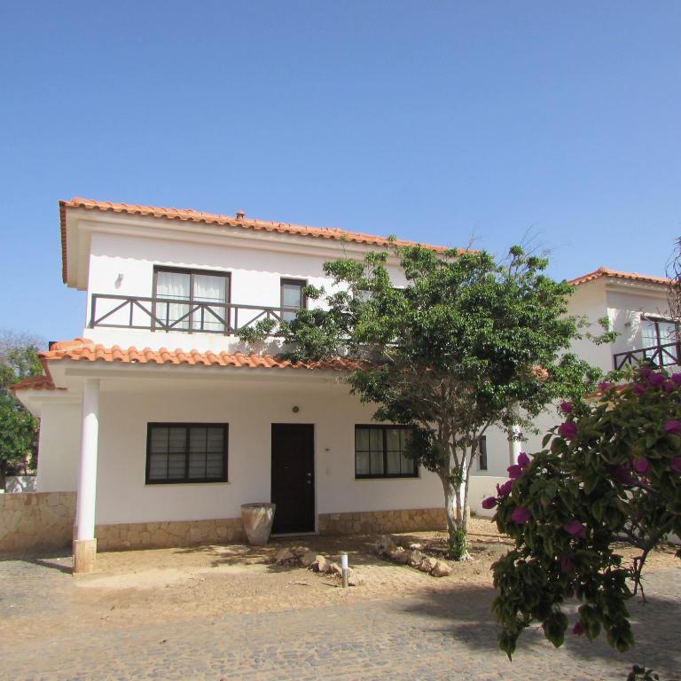 uma casa branca com uma árvore em frente em Tortuga Beach Resort 3 Bed Villa with pool em Santa Maria