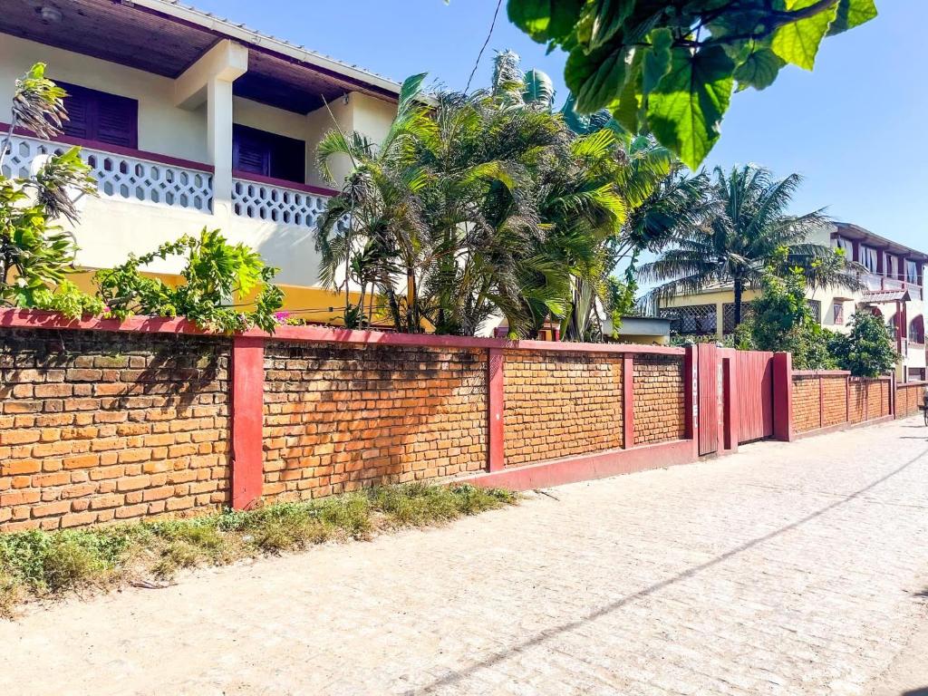 a brick fence in front of a building at Le Famanta - Hotel & Restaurant in Fort Dauphin