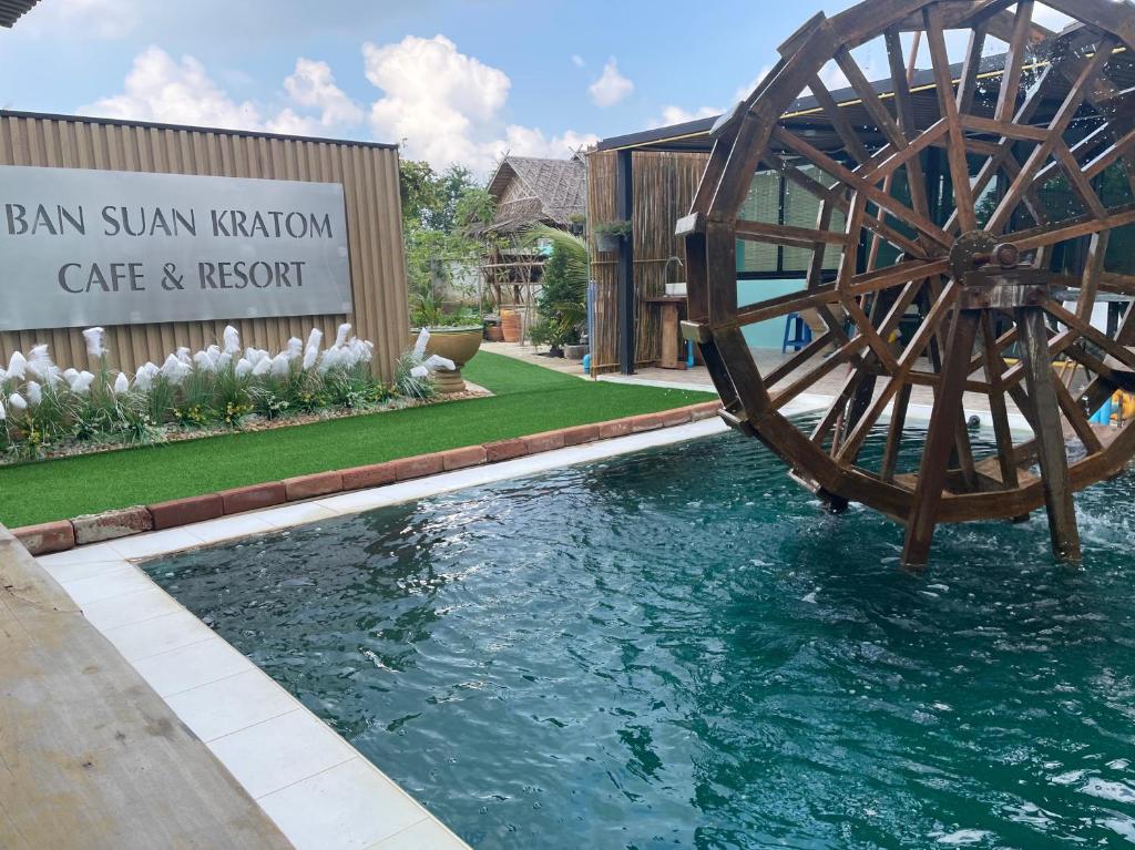 a water wheel in the middle of a swimming pool at BAN SUAN KRATOM CAFE AND RESORT in Nakhon Pathom