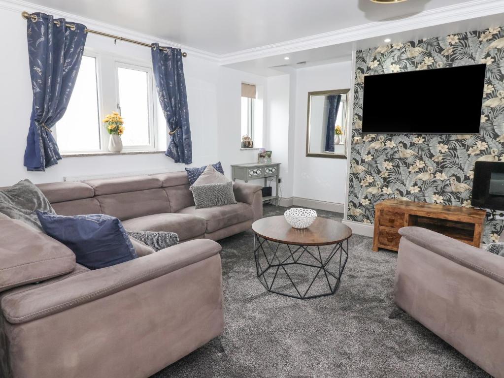 a living room with a couch and a tv at 4 Lock View in Skipton