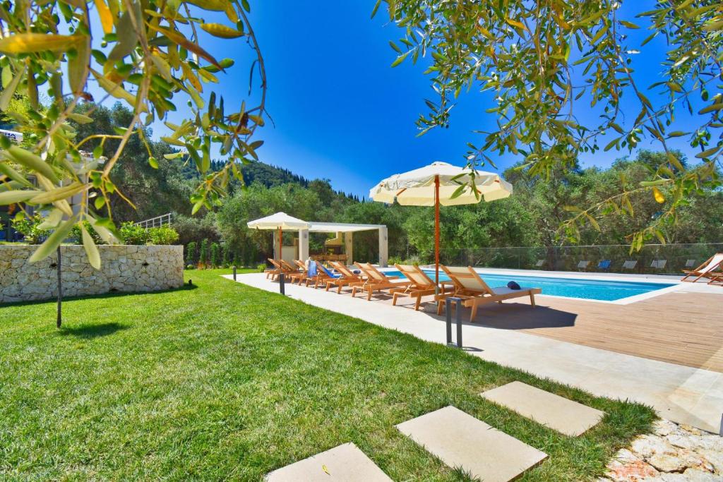 een achtertuin met een zwembad met stoelen en een parasol bij Minerva Estate Corfu in Alepochórion