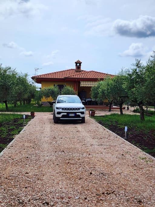 a car parked on a gravel road in front of a house at la casa di simone in Torre Tre Ponti