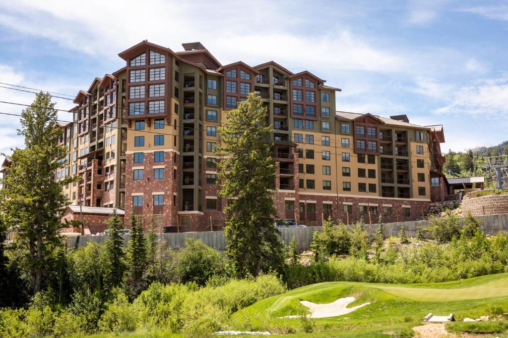 un complejo de apartamentos con un campo de golf en el primer plano en Grand Summit Lodge by Park City - Canyons Village, en Park City