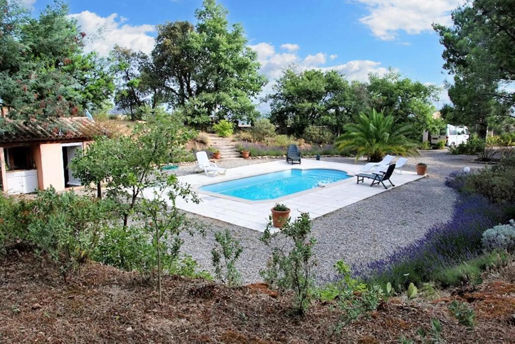 - une piscine dans un jardin avec 2 chaises à côté dans l'établissement Villa charmante à Le Plan-de-la-Tour avec piscine privée, à Le Revest-les-Eaux