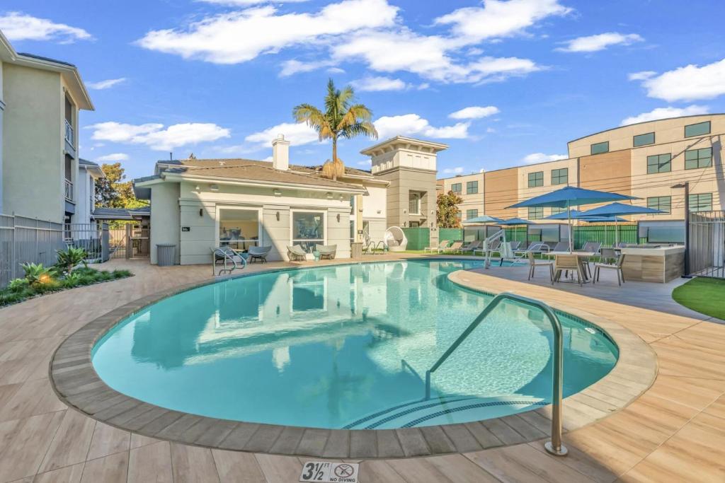 une grande piscine dans une cour avec une maison dans l'établissement MDR Furnished Apartments, à Los Angeles
