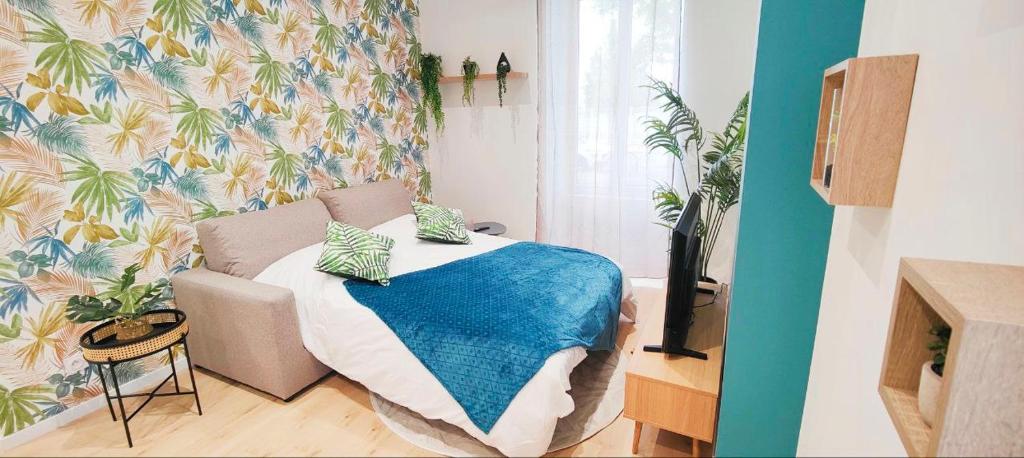 sypialnia z łóżkiem z niebieskim kocem w obiekcie Appartements à thème w mieście Clermont-Ferrand