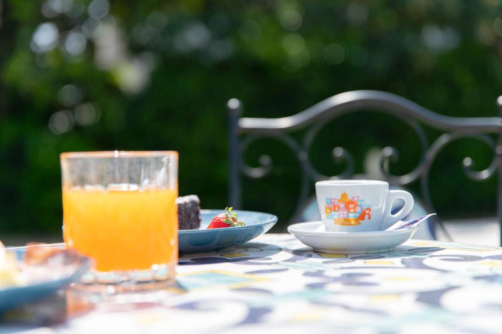 a table with a glass of orange juice and a cup of tea at Il Leone Di Mare in Procida