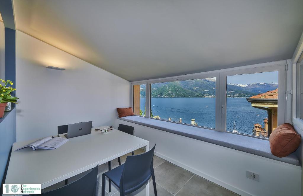 a room with a large window and a table and chairs at Casa Posta in Varenna