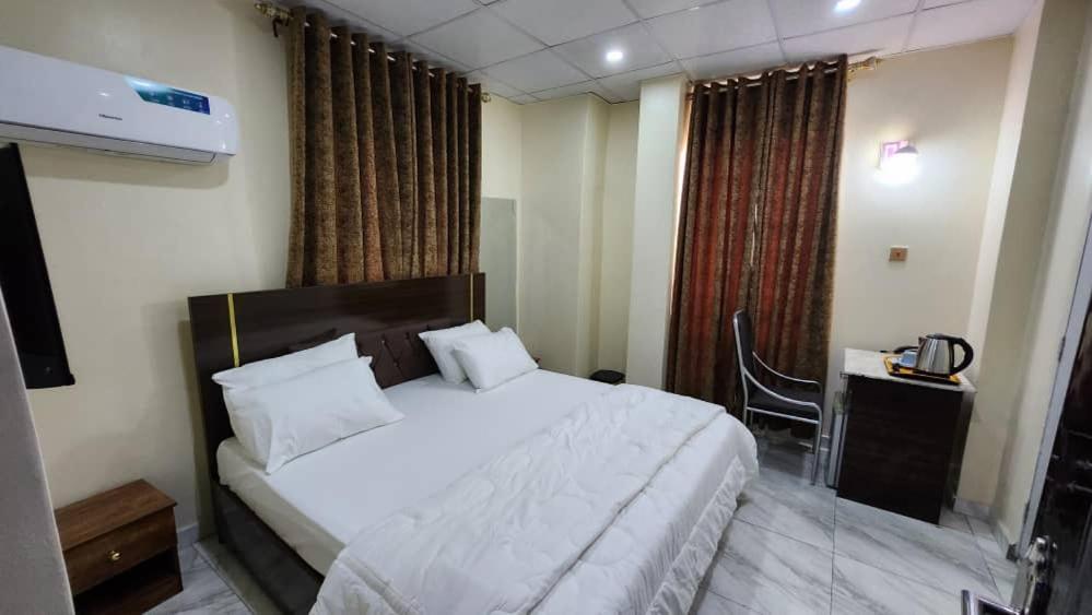 a bedroom with a bed and a desk with a chair at Ceetran Hotels in Port Harcourt