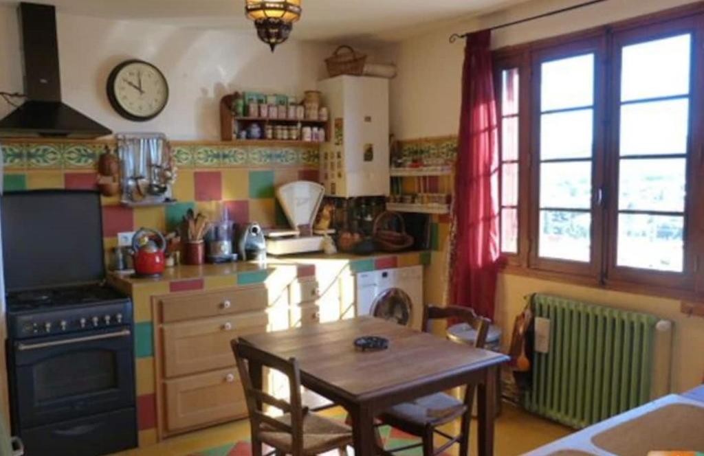 a kitchen with a table and a clock on the wall at Chambre paisible proche calanques et centre La Ciotat in La Ciotat