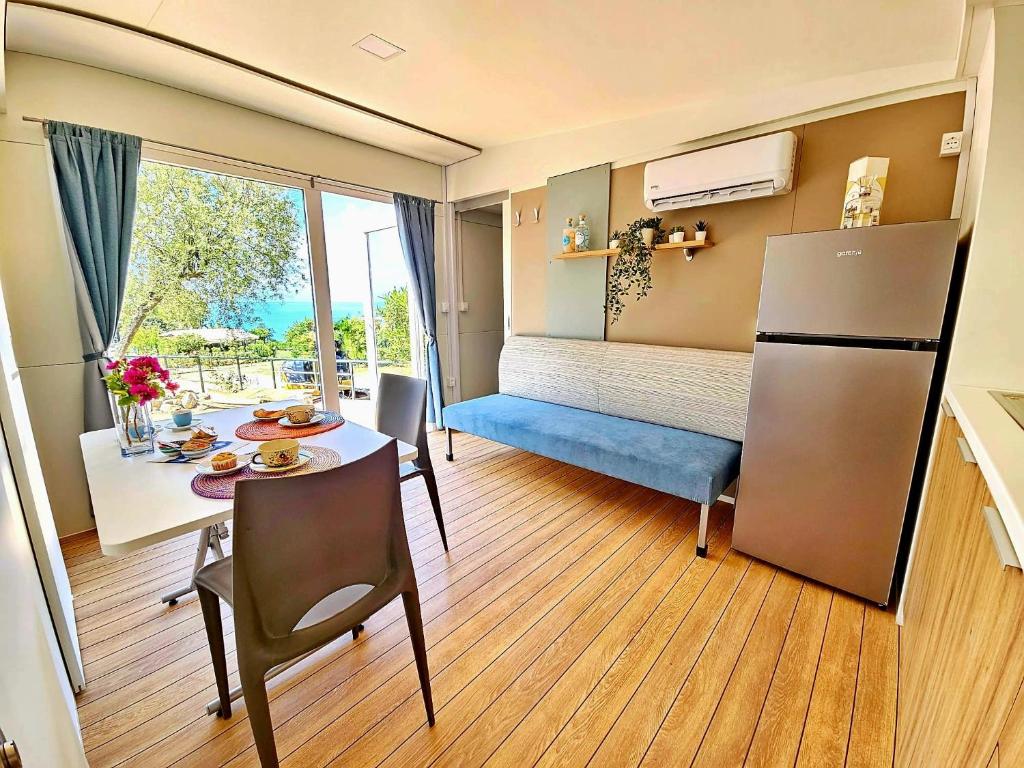 een kleine kamer met een tafel en een koelkast bij Villaggio Acquamarina in Pisciotta
