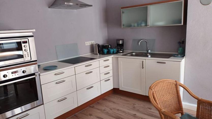 a kitchen with white cabinets and a sink at Ferienhaus Valler in Vallendar