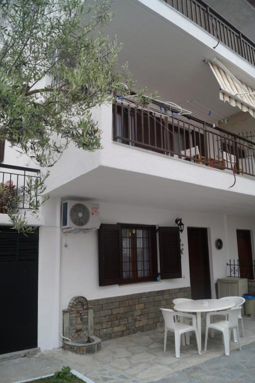 a white house with a table in front of it at Tea's sea apartments in Siviri