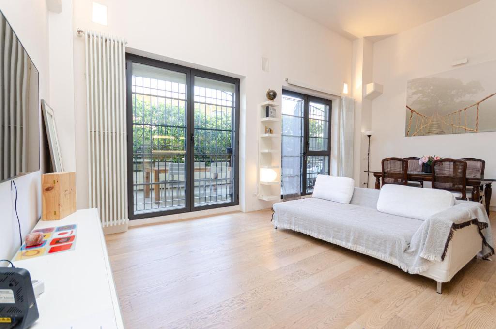 - un salon avec un lit et quelques fenêtres dans l'établissement Esclusivo loft con due camere da letto e terrazzo, à Milan
