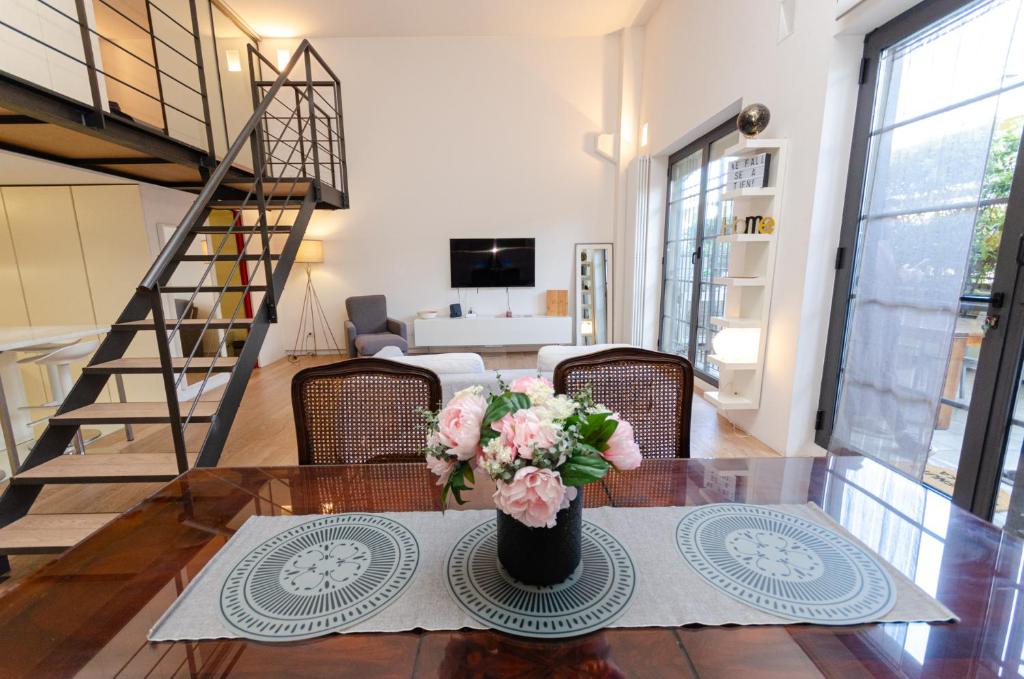tavolo da pranzo con vaso di fiori di Esclusivo loft con due camere da letto e terrazzo a Milano
