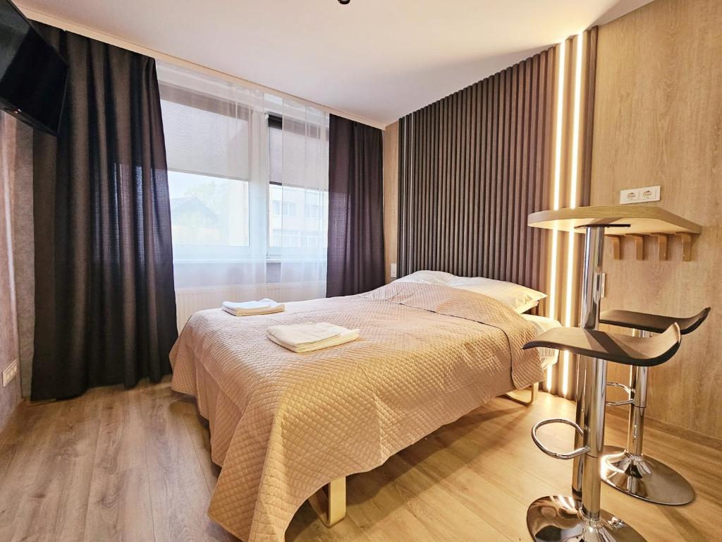 sypialnia z dużym łóżkiem i oknem w obiekcie Vilnius Tiny apartments w Wilnie