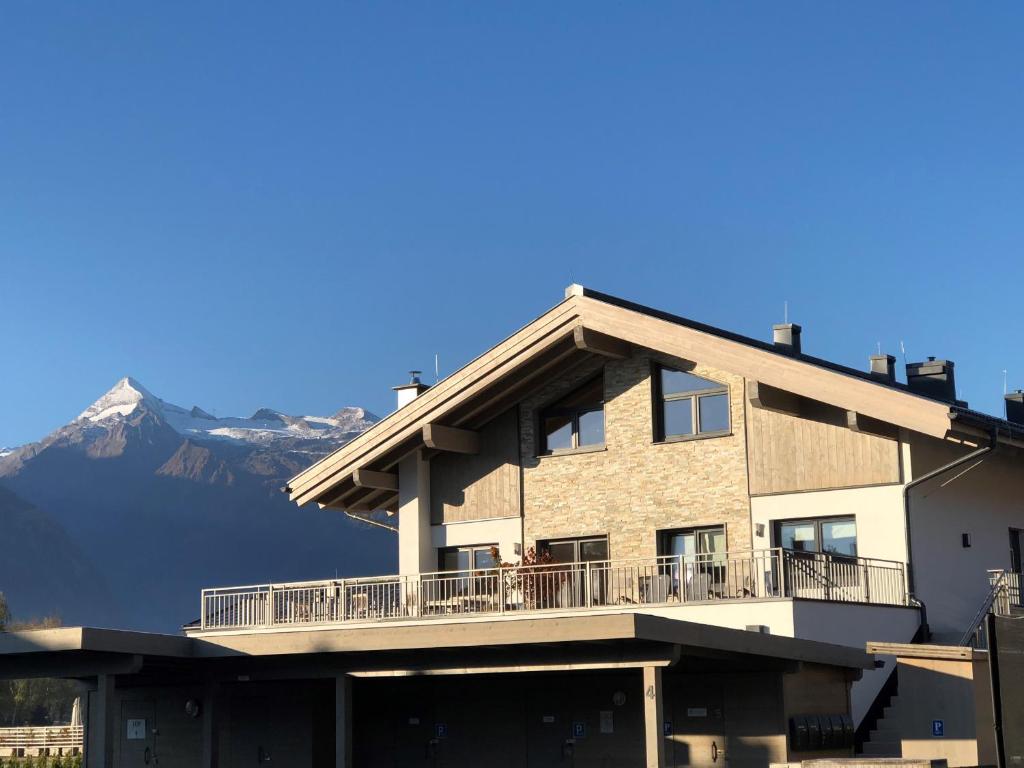 a building with a balcony with mountains in the background at KitzviewTerrace in Zell am See