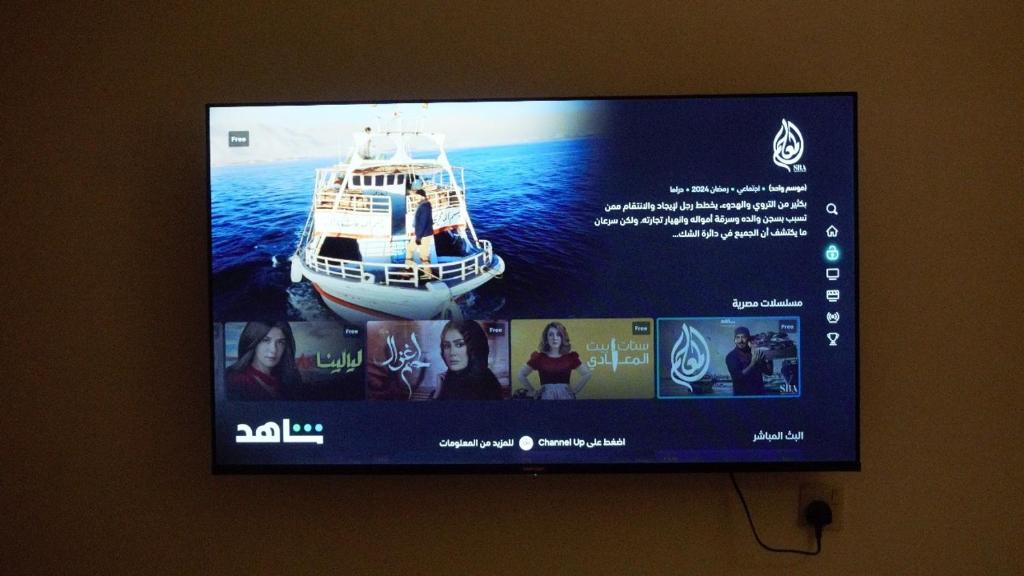 een flatscreen-tv aan een muur bij Cozy one bedroom apartment in Riyad