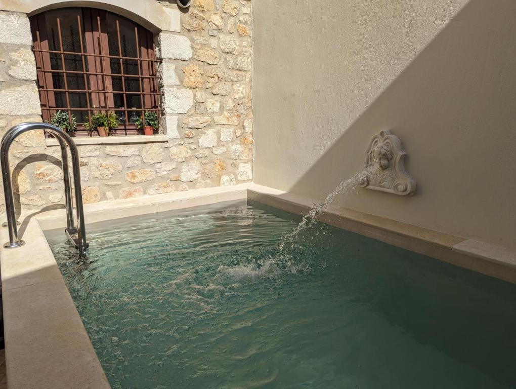 a pool with a water fountain in a building at Casa Leone, whole house with private pool! in Atsipopoulo