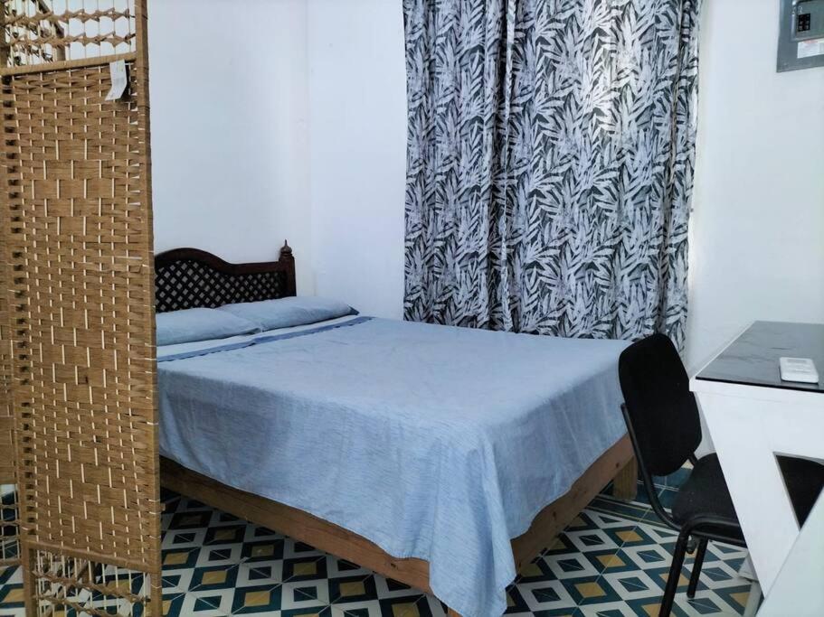 1 dormitorio con 1 cama con cortina y escritorio en Suite Jacinto en Villahermosa